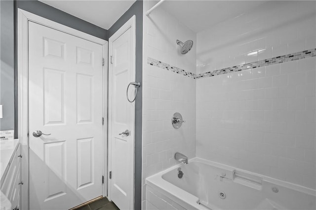 bathroom featuring tile patterned floors, vanity, and tiled shower / bath