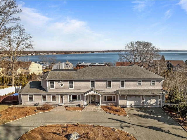 view of front of home with a garage and a water view