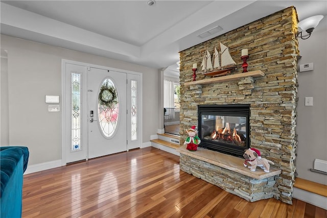 foyer with wood-type flooring and a fireplace