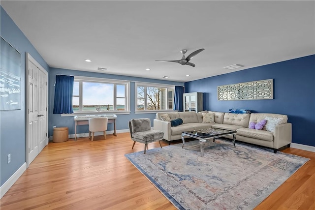 living room with ceiling fan and light hardwood / wood-style flooring