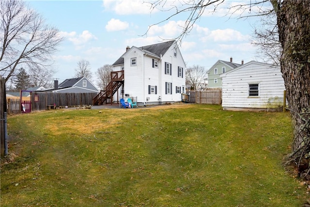 back of house with a deck, a yard, and a shed