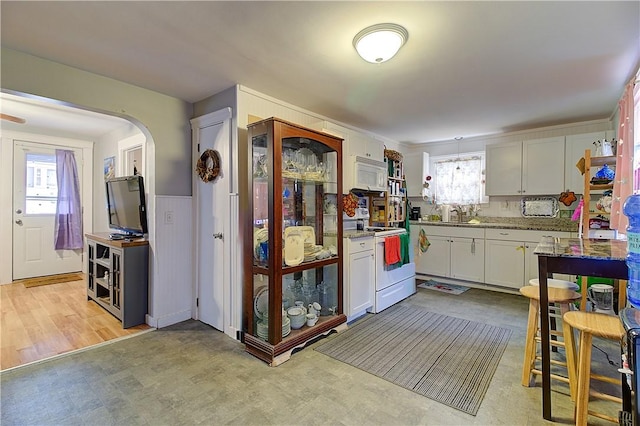 kitchen with light stone countertops, white cabinetry, sink, and white appliances