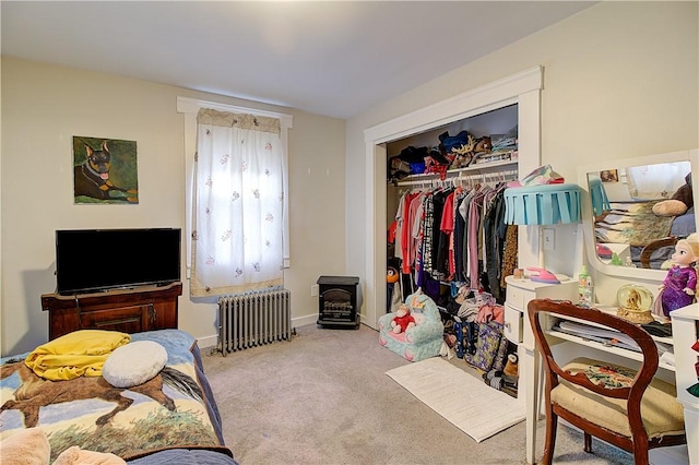 bedroom with radiator, a closet, and light colored carpet