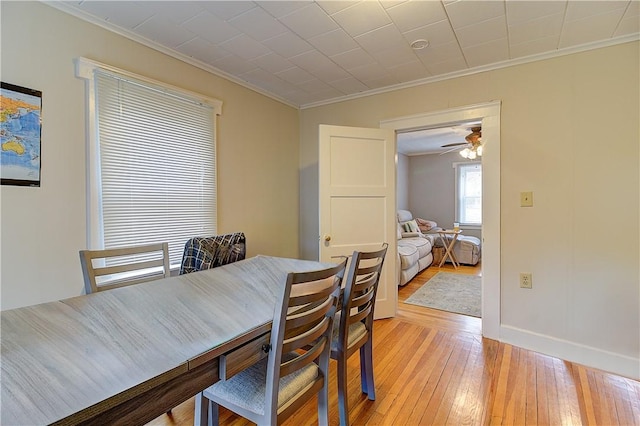 dining room with ornamental molding and light hardwood / wood-style floors