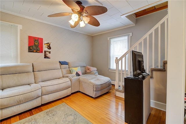 living room featuring ceiling fan, ornamental molding, and hardwood / wood-style flooring