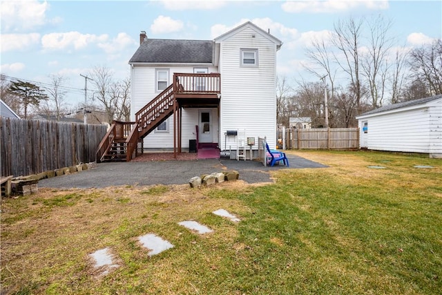 back of house with a patio area, a wooden deck, and a yard