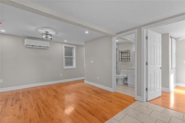 empty room with a wall mounted AC and light wood-type flooring