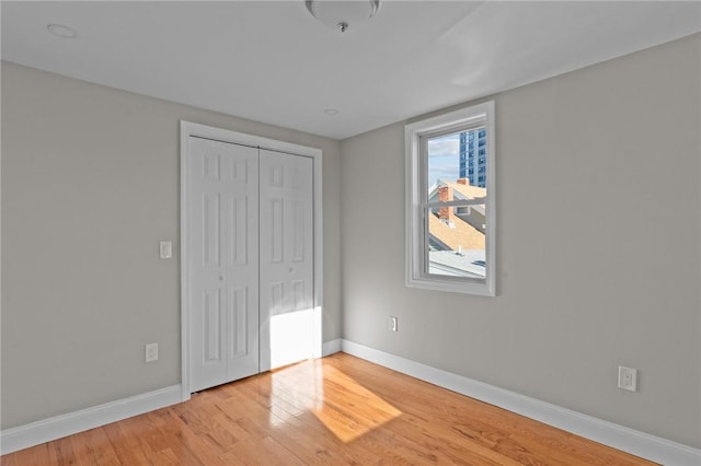 unfurnished bedroom featuring a closet and light wood-type flooring