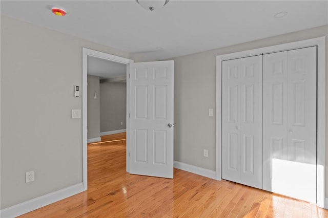 unfurnished bedroom with a closet and light hardwood / wood-style flooring