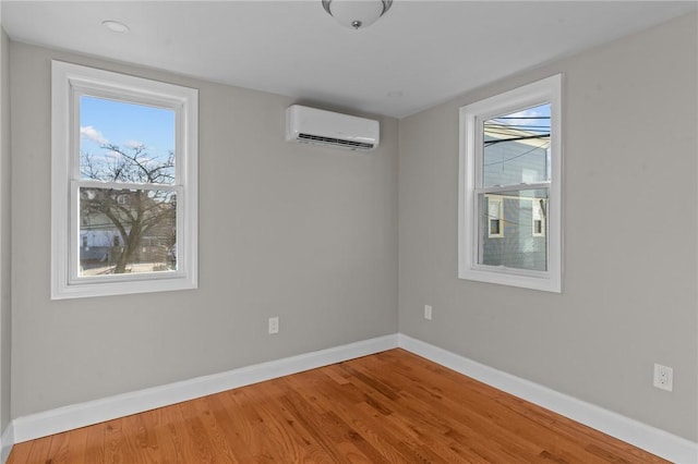 spare room featuring a wall mounted AC and hardwood / wood-style floors