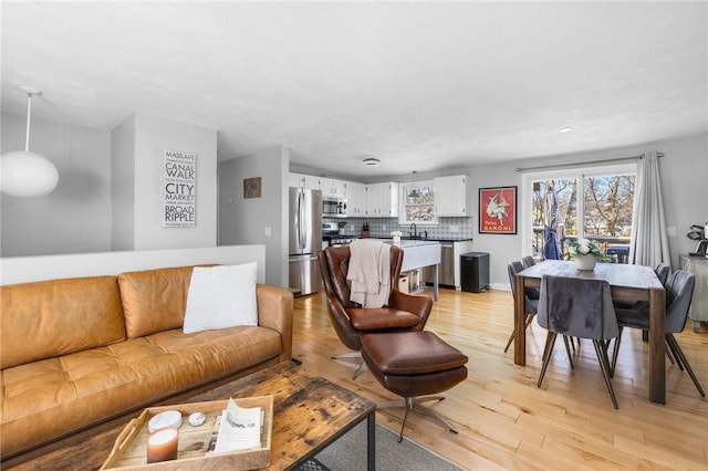 living room with sink and light wood-type flooring