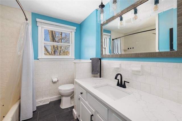 full bathroom with toilet, shower / tub combo with curtain, tile patterned flooring, tile walls, and vanity