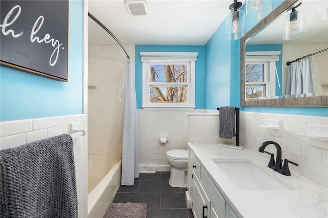 full bathroom featuring tile patterned flooring, tile walls, and plenty of natural light