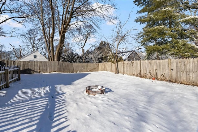 yard covered in snow with a fire pit