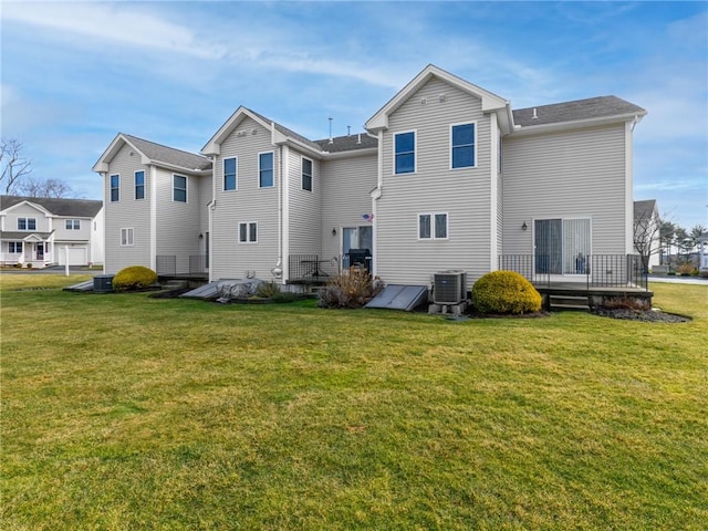 back of property featuring a lawn, central AC unit, and a wooden deck