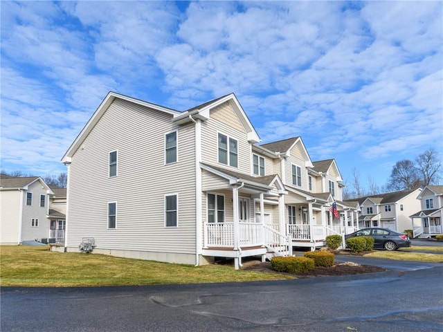 view of side of home featuring a lawn and a porch