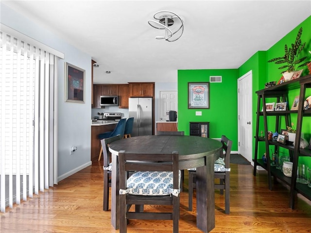 dining space with light hardwood / wood-style floors