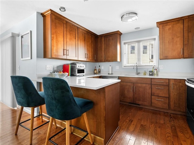 kitchen with a kitchen bar, dark hardwood / wood-style floors, and sink