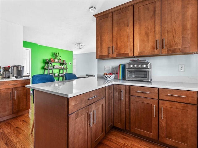 kitchen featuring kitchen peninsula and hardwood / wood-style flooring