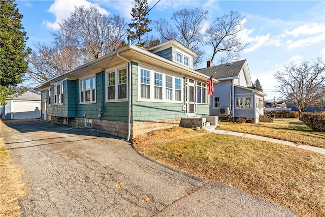 view of front of home featuring a front yard, an outbuilding, and a garage