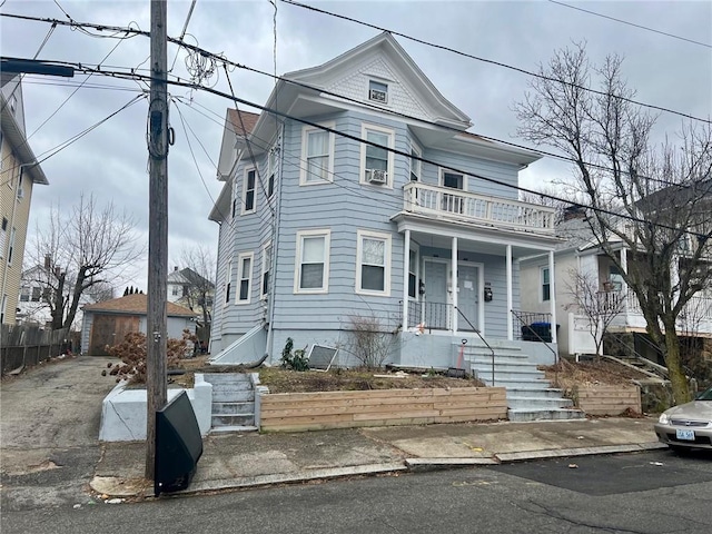 view of front of property featuring a balcony, a porch, and a garage