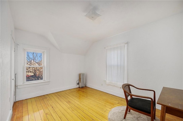 interior space featuring hardwood / wood-style floors, radiator heating unit, and lofted ceiling