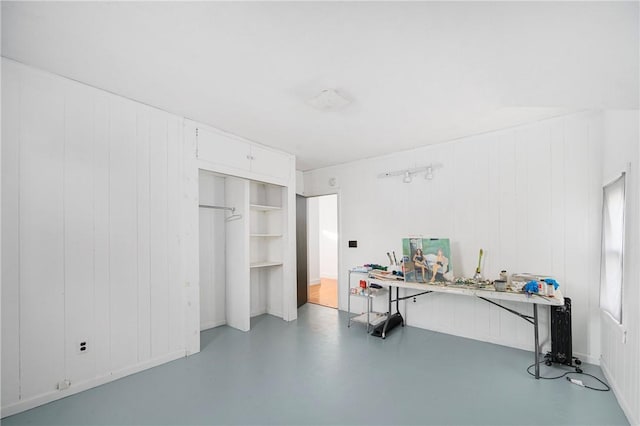 home office with concrete floors and wood walls