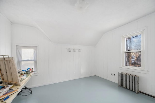 bonus room featuring radiator, concrete floors, vaulted ceiling, and wood walls