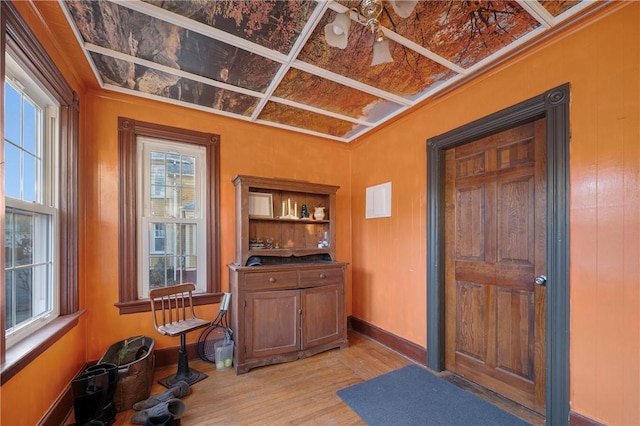 bar featuring coffered ceiling and light hardwood / wood-style floors