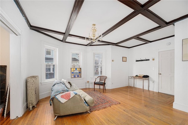 sitting room featuring a chandelier, wood-type flooring, coffered ceiling, and beamed ceiling