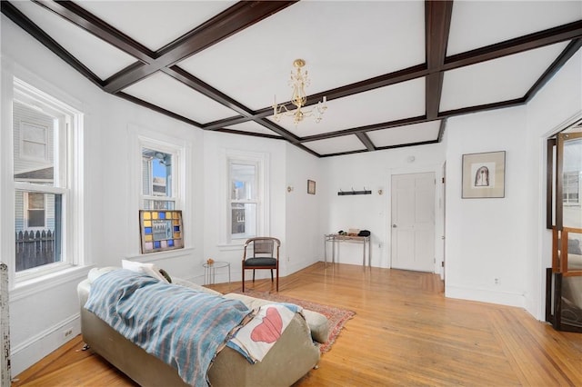 living room with light wood-type flooring, an inviting chandelier, beam ceiling, and coffered ceiling