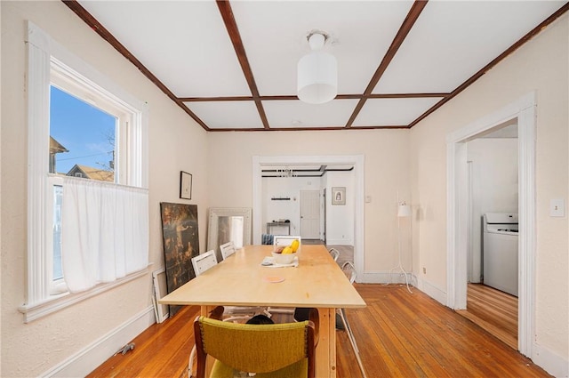 dining space featuring coffered ceiling and hardwood / wood-style flooring