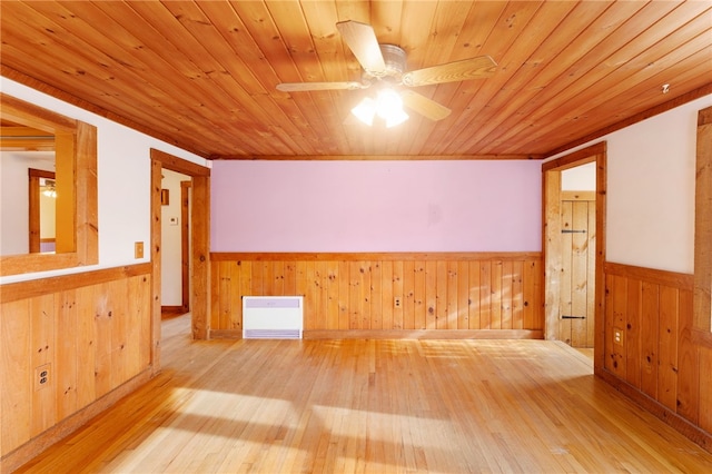 spare room with ceiling fan, wood walls, wood-type flooring, wood ceiling, and ornamental molding