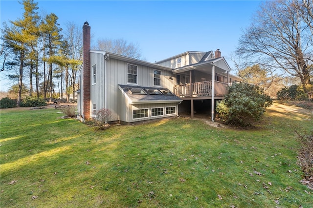 rear view of property with a lawn and a wooden deck