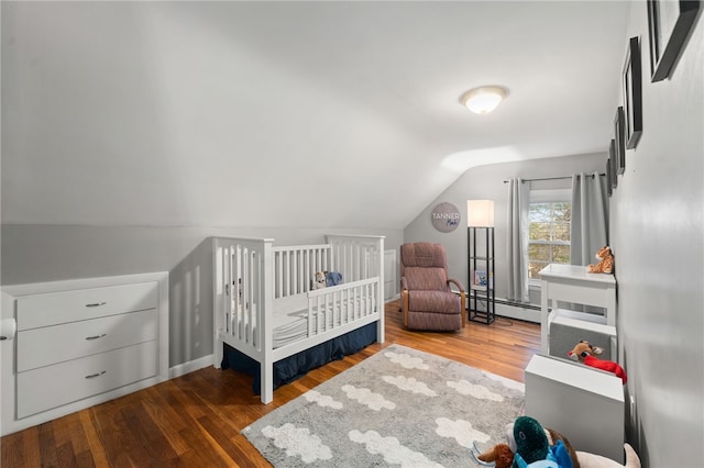 bedroom with lofted ceiling, a baseboard heating unit, a nursery area, and wood-type flooring