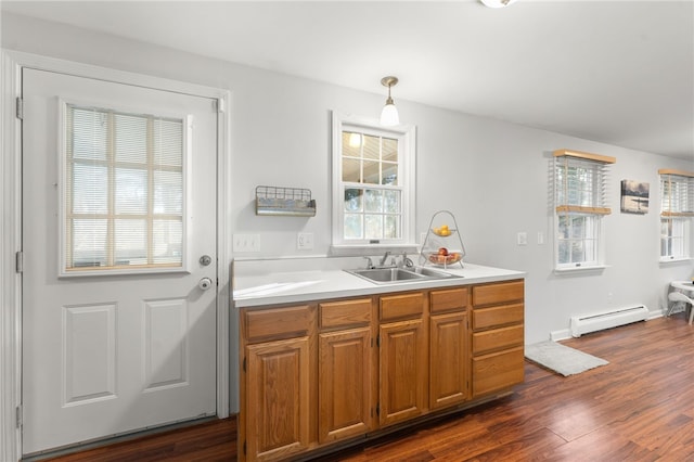 kitchen with baseboard heating, dark hardwood / wood-style floors, sink, and pendant lighting