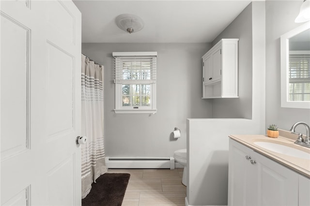 bathroom featuring a baseboard heating unit, vanity, and toilet