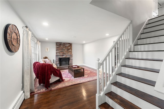 living room with a baseboard radiator, dark hardwood / wood-style flooring, and a fireplace