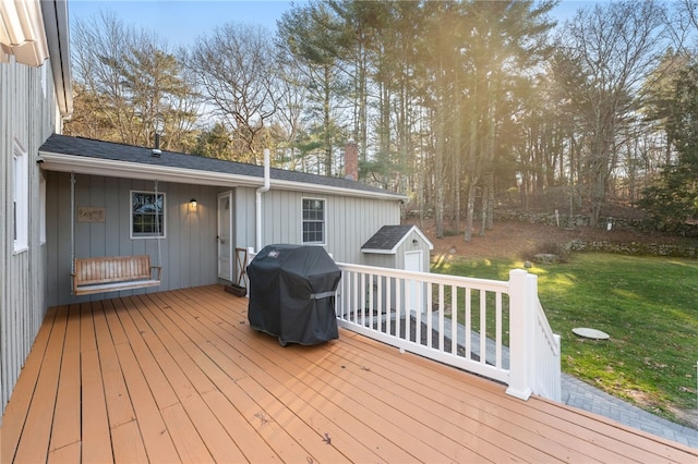 deck with a shed, area for grilling, and a yard