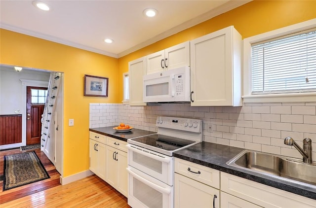 kitchen with white cabinetry, backsplash, white appliances, light hardwood / wood-style flooring, and sink