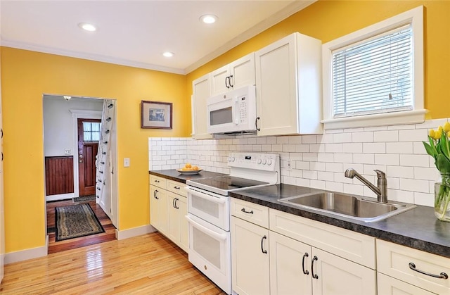 kitchen featuring backsplash, white appliances, ornamental molding, white cabinets, and sink