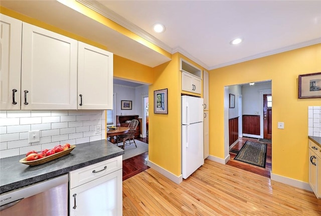 kitchen with white fridge, white cabinetry, and decorative backsplash