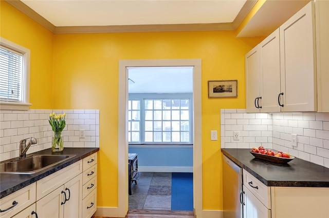 kitchen with white cabinetry, ornamental molding, tasteful backsplash, and sink