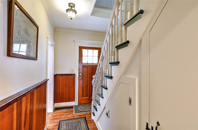 doorway to outside featuring wood walls, light hardwood / wood-style flooring, and crown molding