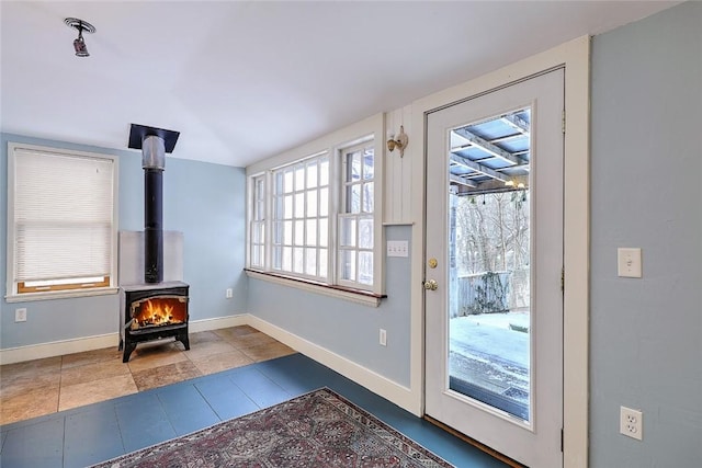 doorway featuring light tile patterned floors and a wood stove