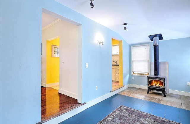 exercise room with a wood stove and lofted ceiling