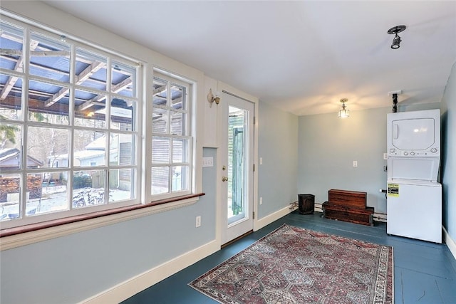 entryway featuring plenty of natural light and stacked washer and clothes dryer