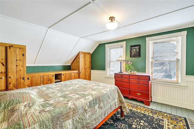 bedroom with lofted ceiling and multiple windows