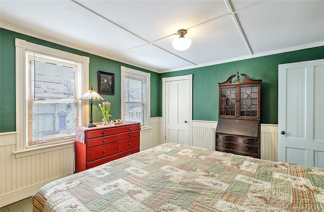 bedroom with a closet, crown molding, and multiple windows