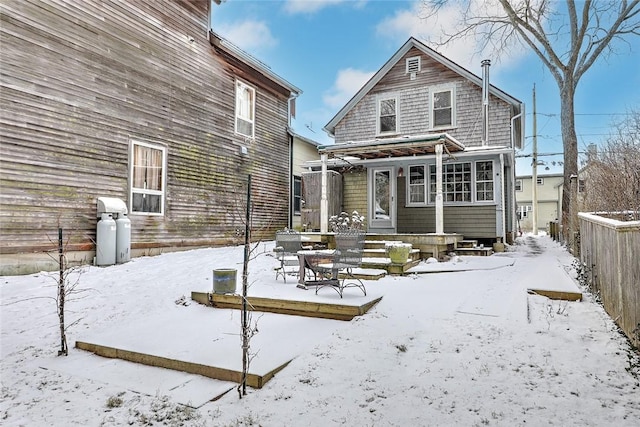 view of snow covered back of property